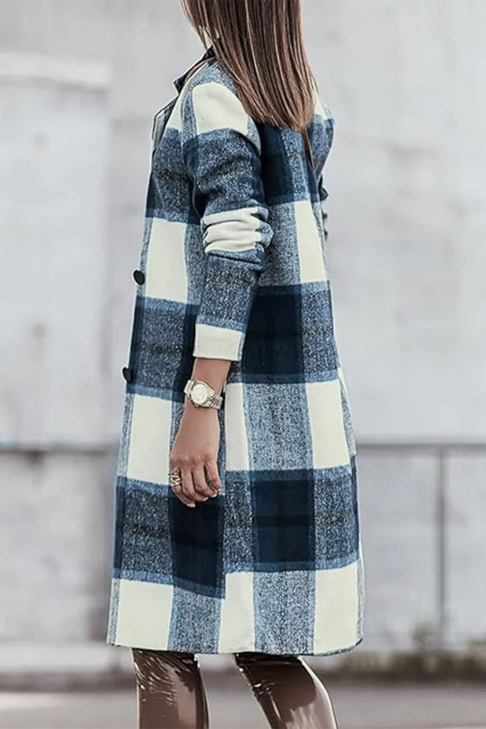 Person wearing a blue and white plaid coat with a blurred background