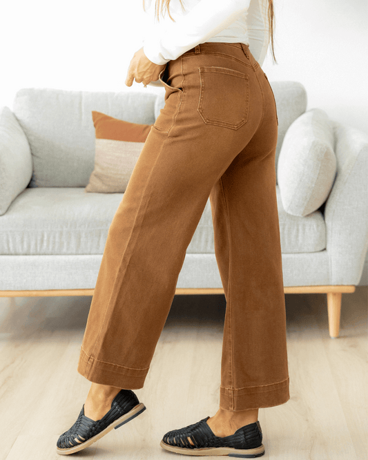 Person wearing brown wide leg cropped jeans.