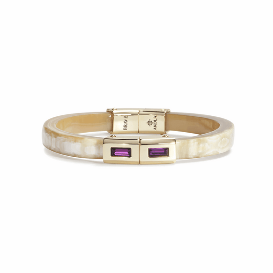 Gold bracelet with purple gemstones on a white background