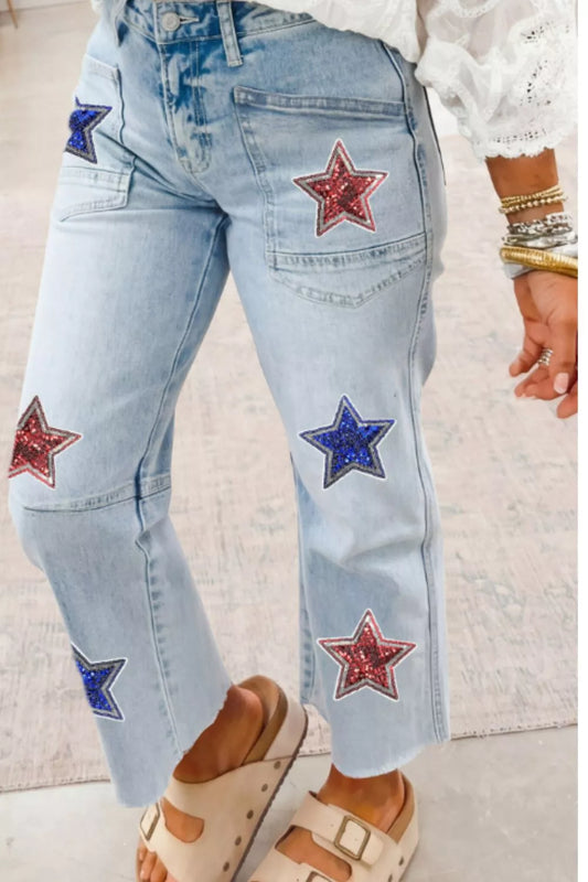 Light blue jeans with star patches worn by a person on a light background