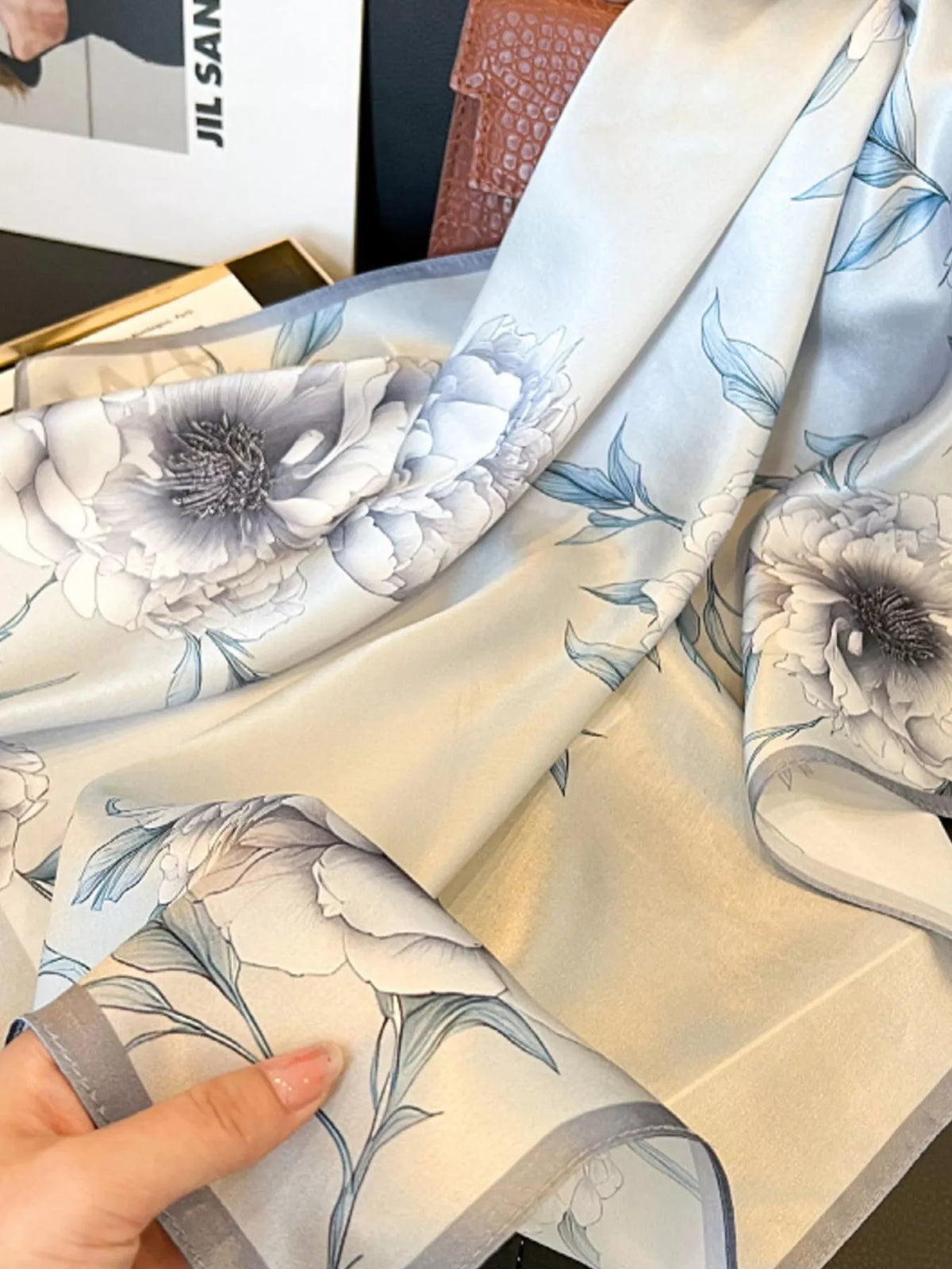 Close-up of the floral print pattern on a premium silk square scarf