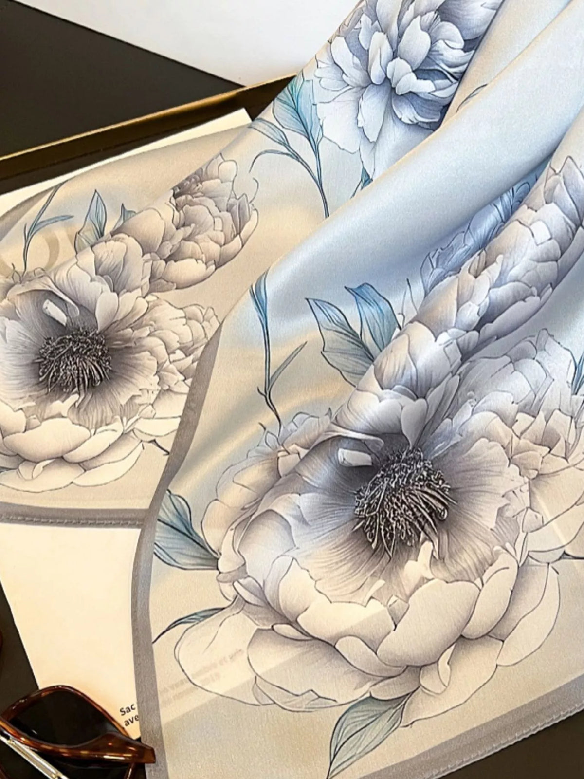 Close-up of the floral print pattern on a premium silk square scarf