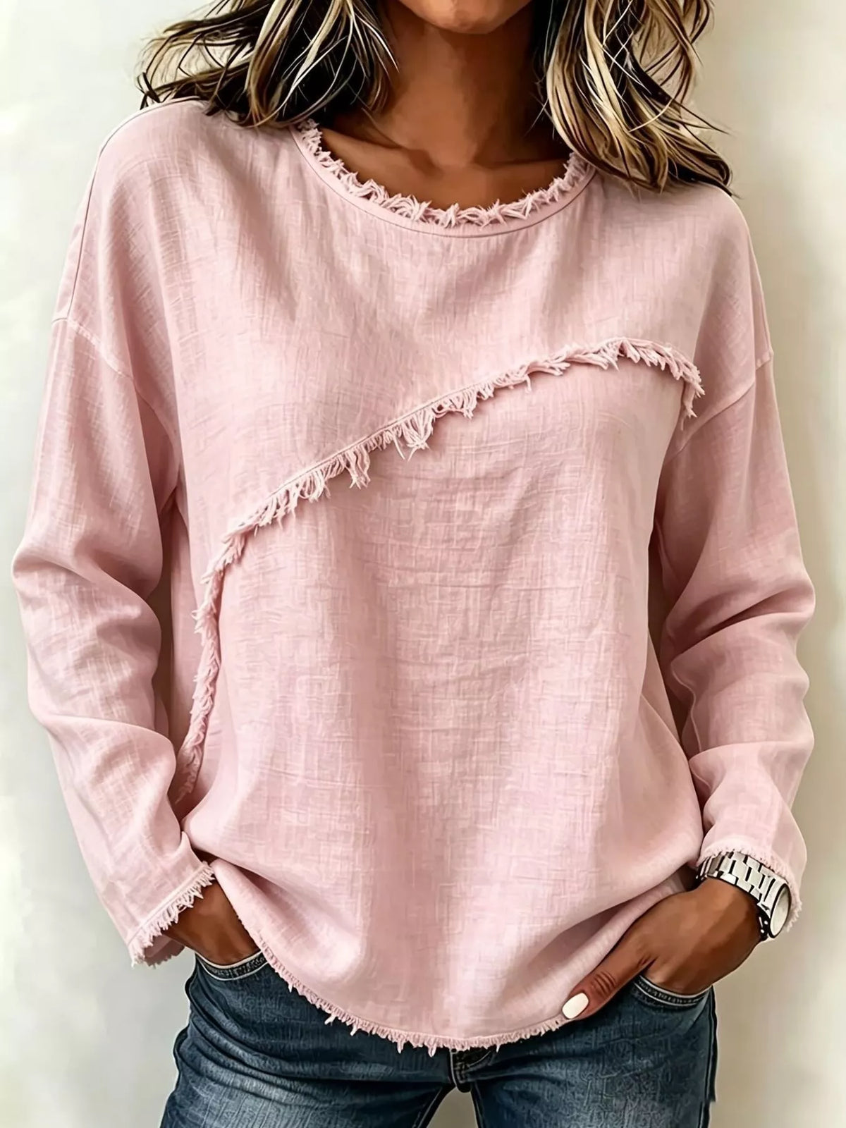 Person wearing a pink sweatshirt with ruffled details on a plain background