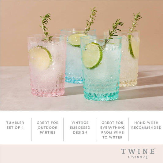 Set of four tumblers with vintage embossed design, containing drinks with lime slices and rosemary sprigs.