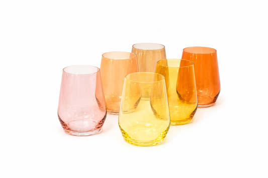 Six stemless glass wine tumblers in a pink, orange, and yellow ombre color palette arranged on a white background.