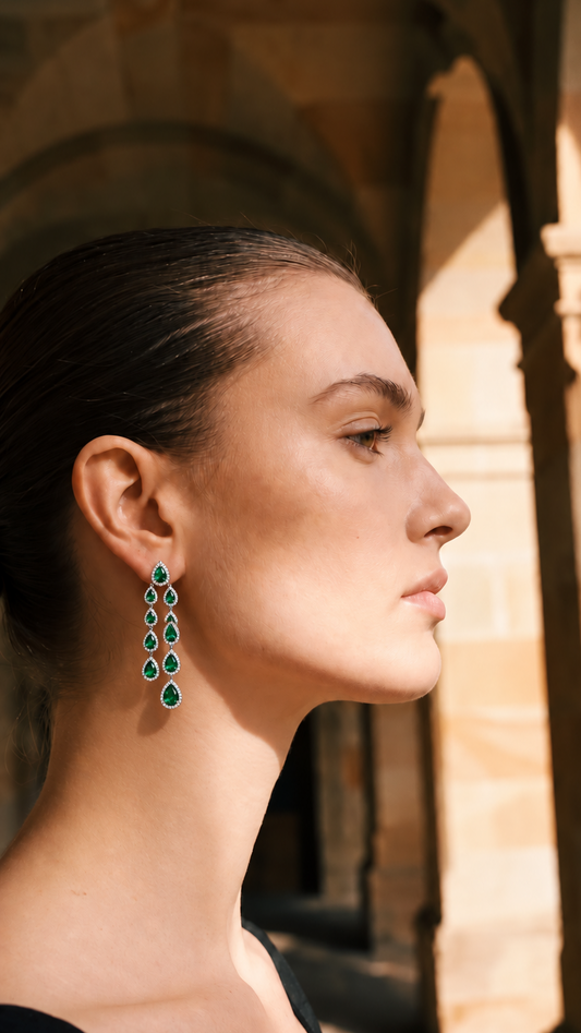 Emerald green earrings on a woman.