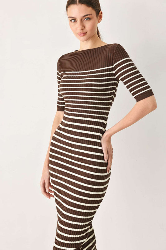 A woman modeling a brown and cream striped ribbed knit midi dress with a boat neckline and elbow-length sleeves, set against a plain light gray studio background.