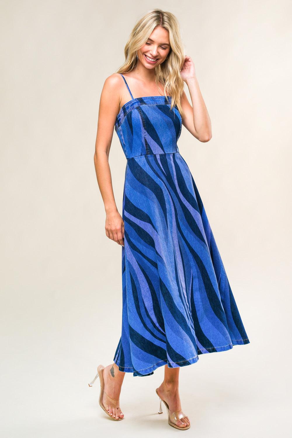 Woman wearing a blue and black striped dress on a beige background