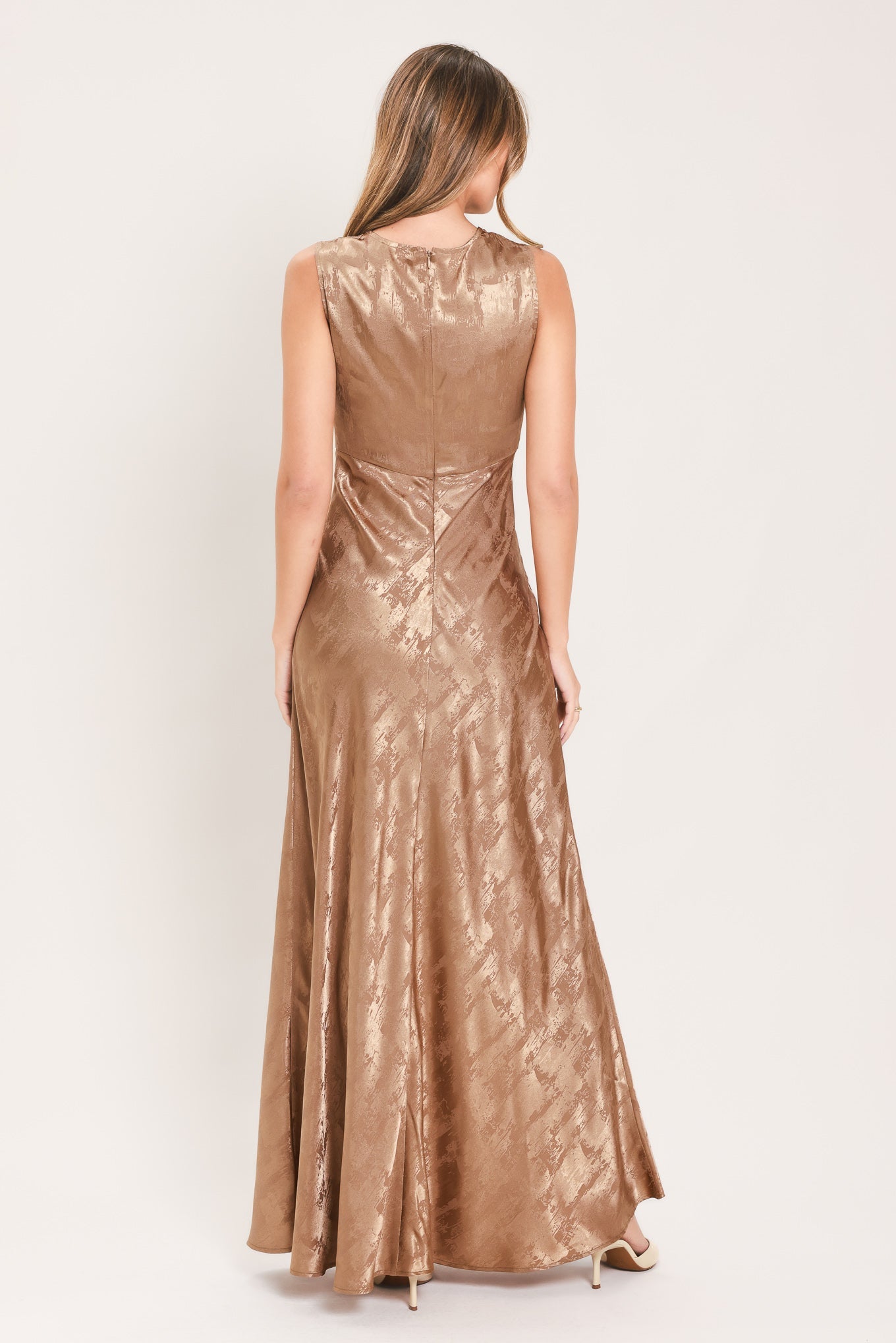 back view of sleeveless gown for evening in a champagne color subtle metallic finish and textured jacquard detailing