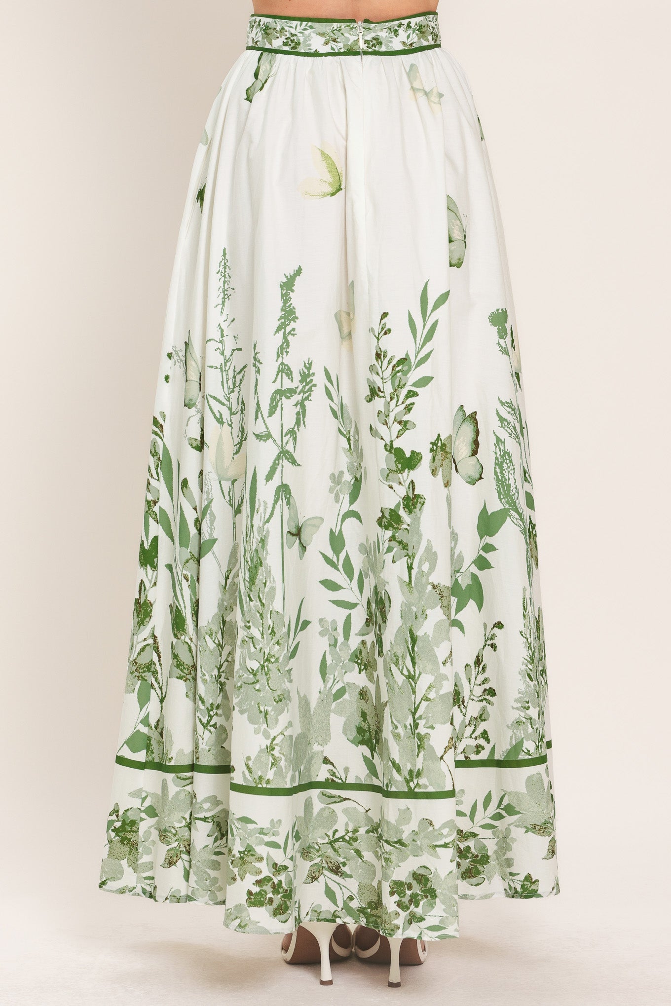 Long white skirt with green floral pattern on a plain background