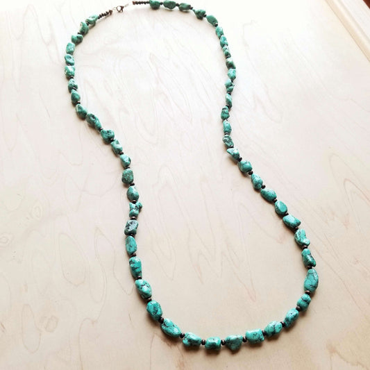 Turquoise beaded necklace on a light wooden surface