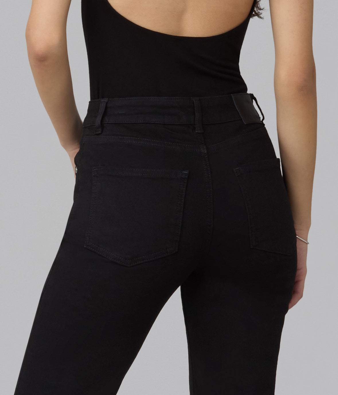 Close-up of Denver black jeans showing the back pockets, waistband, and belt loops.