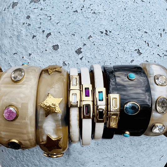 Collection of colorful gemstone bracelets on a textured surface