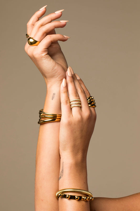Gold Elle Pave Ring with three rows of small crystals worn on a hand with other gold rings and bracelets.