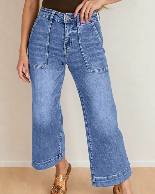 Medium wash blue denim wide leg jeans with large front patch pockets and a high rise waist.