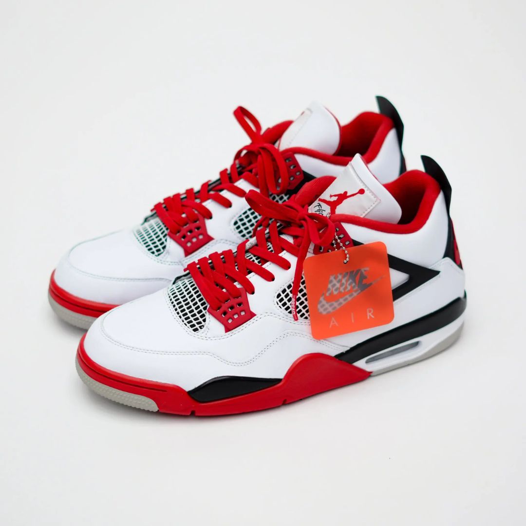 Bold red shoelaces on white and red sneakers with black accents and a tag displaying "Air.