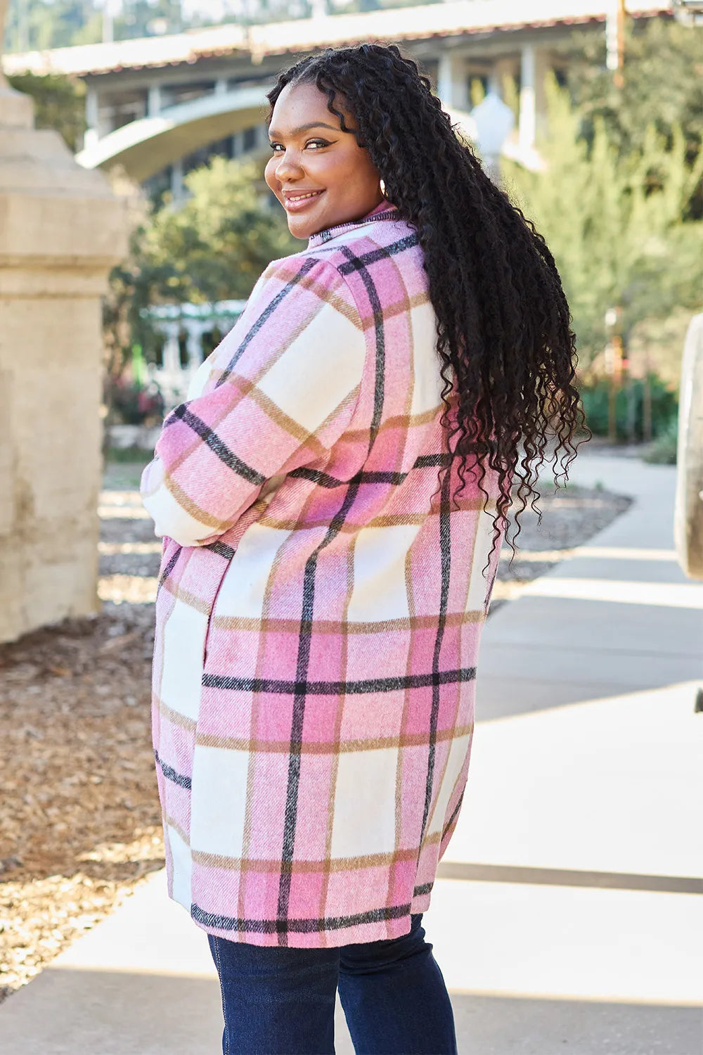 Woman wearing a pink plaid coat outdoors