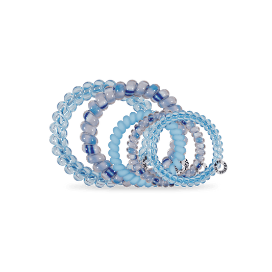 Set of blue beaded bracelets on a black stand against a green background