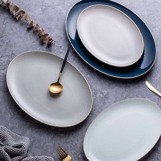 Set of ceramic plates on a gray surface with a spoon and fork.