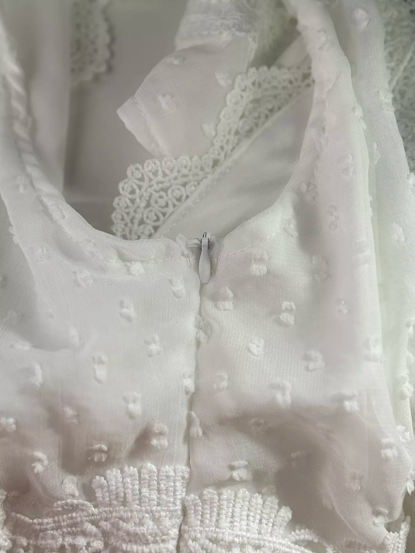 Close-up of a white lace garment with intricate detailing.