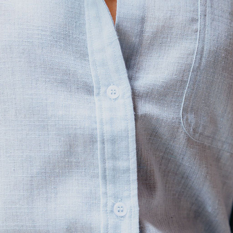 Close-up of a light blue textured shirt with buttons