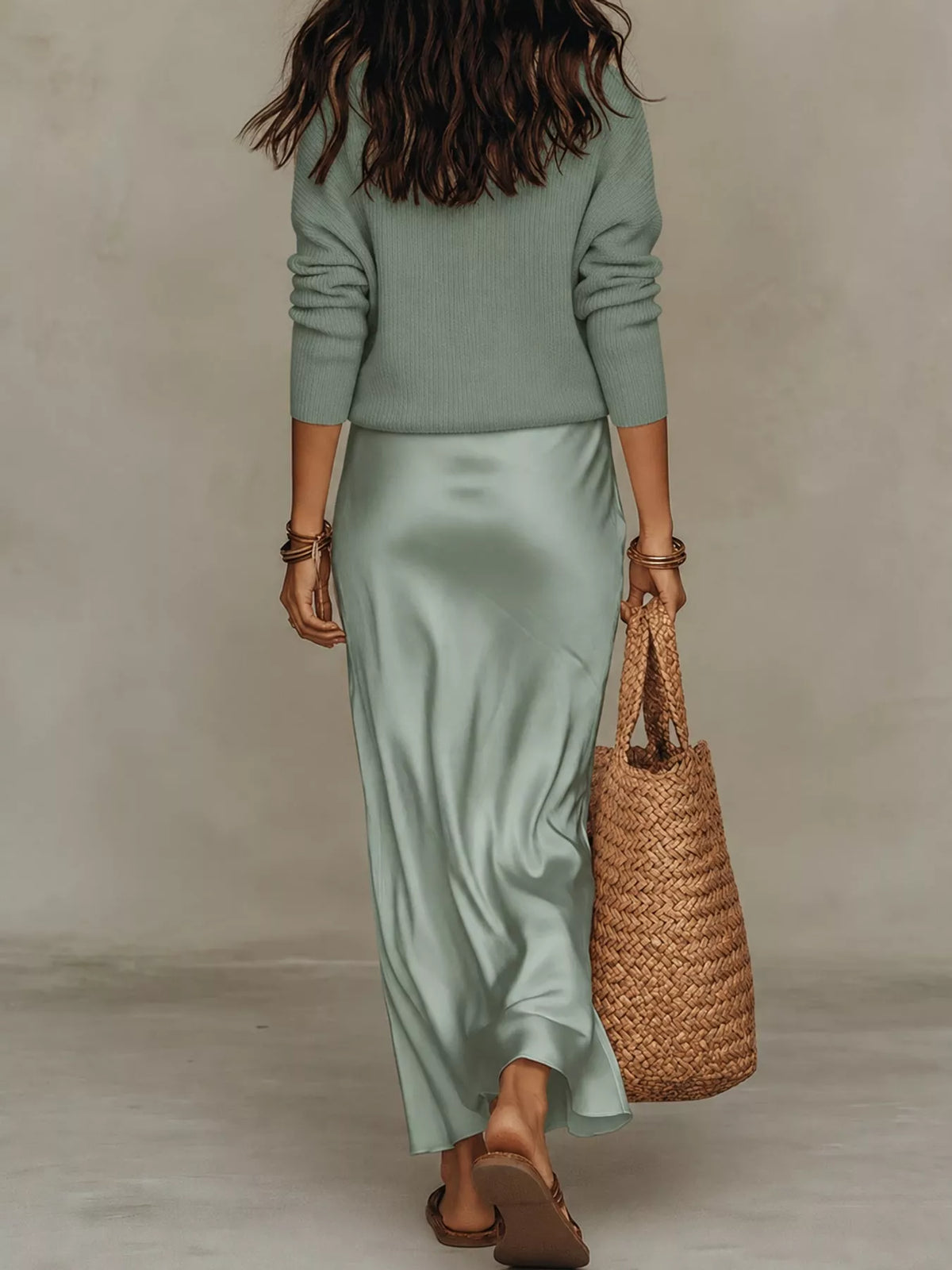Back view of pale green ribbed top and satin midi skirt set.
