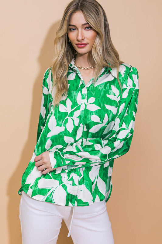Woman wearing a green and white floral blouse against a beige background