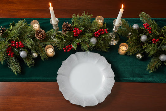 White glass charger plate on a dinning table with a Christmas holiday theme.