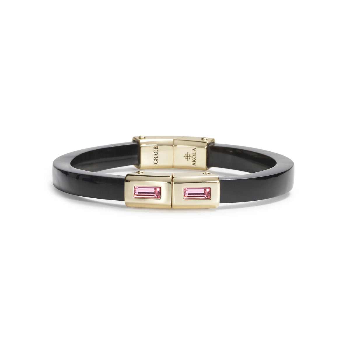 A black enamel bangle bracelet with gold-tone metal accents and rectangular pink baguette-cut crystals, shown on a plain white background.