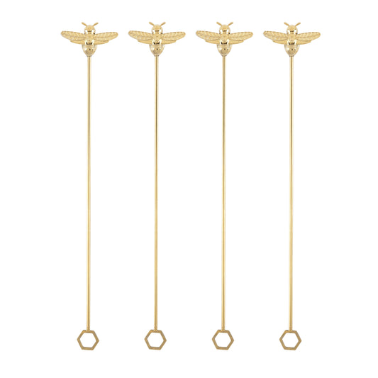 Set of four gold bumble bee stir sticks with hexagonal ends on a white background.
