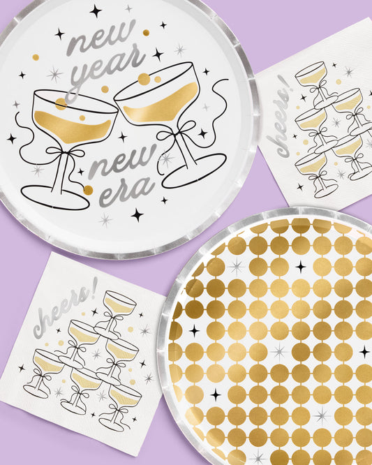 Decorative plates with champagne glass designs and 'new year new era' text on a purple background.