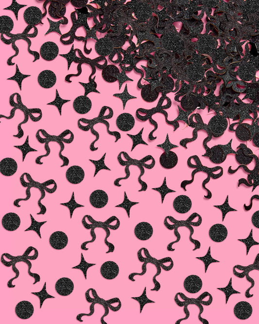 Black decorative confetti shapes on a pink background