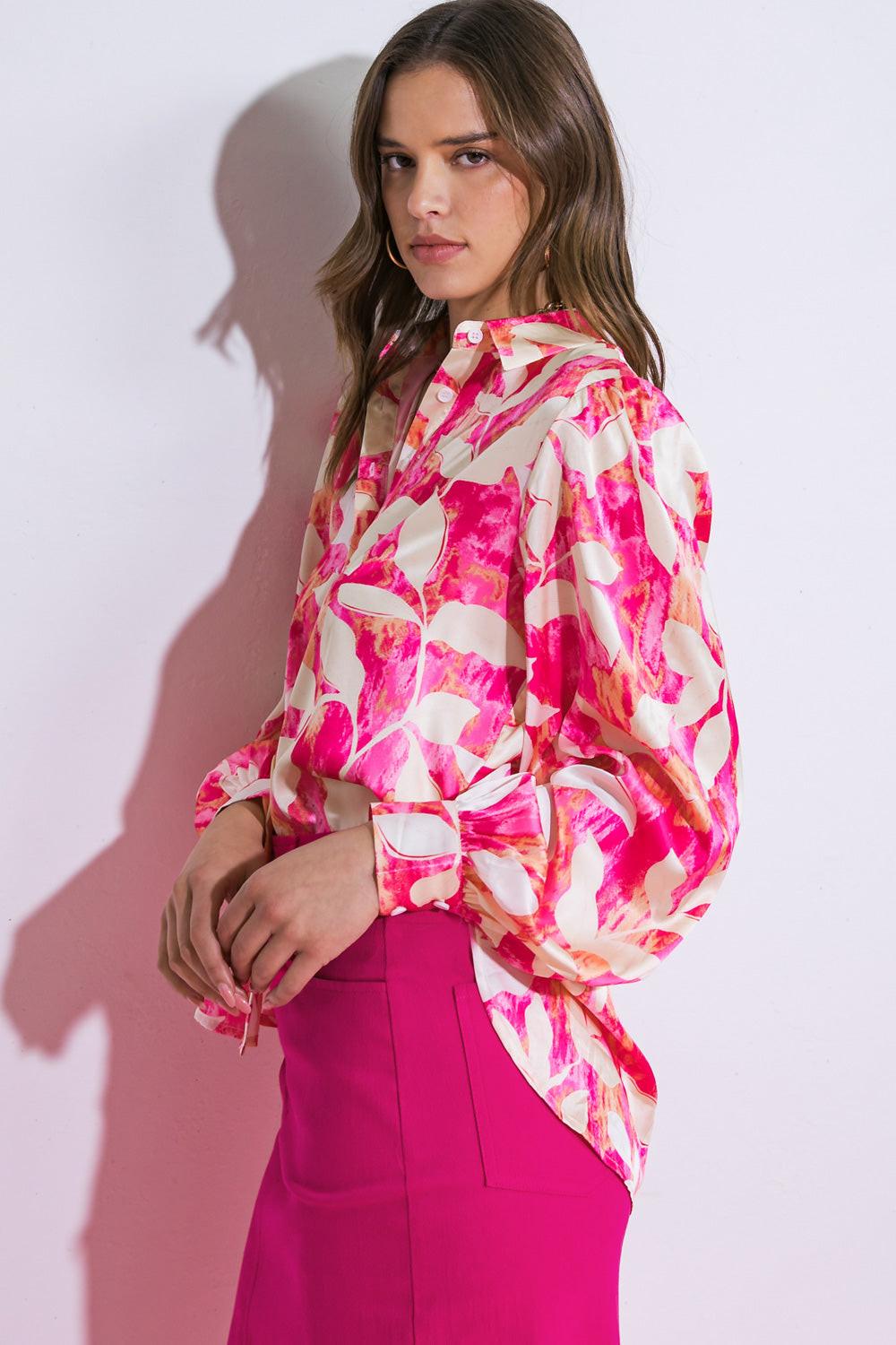 Woman wearing a colorful floral blouse with a plain background