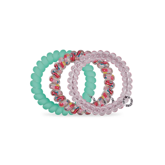 Set of colorful beaded hair ties on a green background