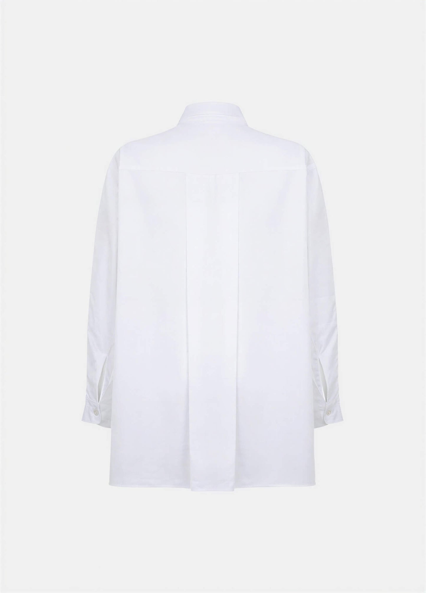 Terza oversized white cotton shirt with a back pleat and long sleeves, displayed on a plain background.