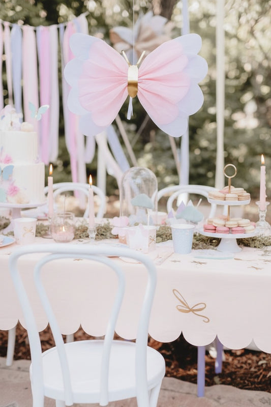 Tissue paper butterfly party decoration hanging over a decorated table.
