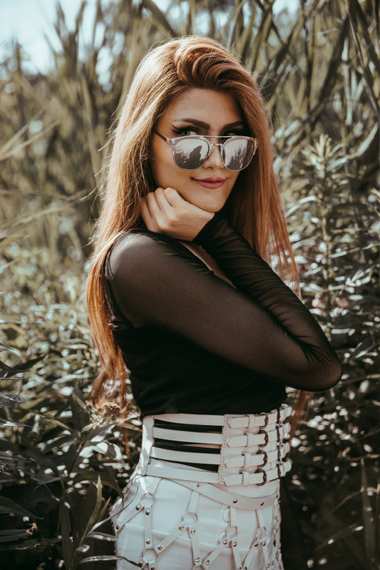 Trendy woman wearing sunglasses and a fashionable outfit posing confidently outdoors
