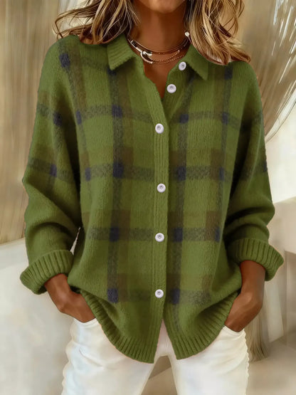 Person wearing a green plaid cardigan with white buttons indoors.