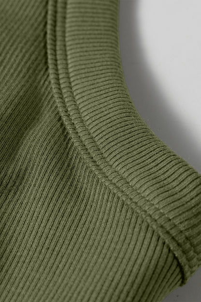 Close-up of a green ribbed sweater sleeve on a white background