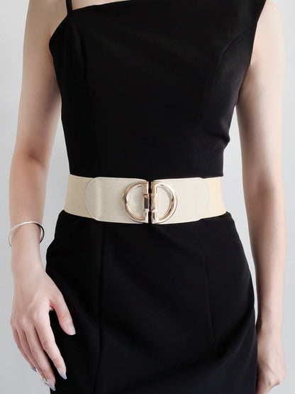 Black dress with a beige belt featuring a gold buckle on a plain background