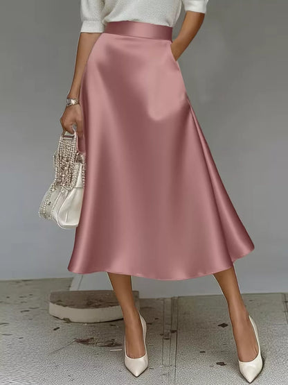 Person wearing a pink satin skirt with a plain background