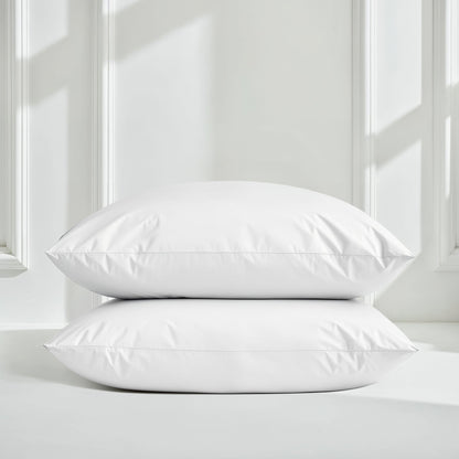 Two white pillows on a bed with a neutral background
