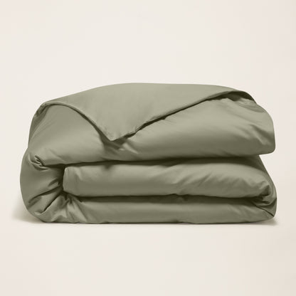 Folded beige comforter on a light beige background