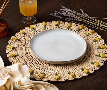 Handmade tulip placemat with raffia crochet, featuring yellow floral accents, set on a dark wooden table.