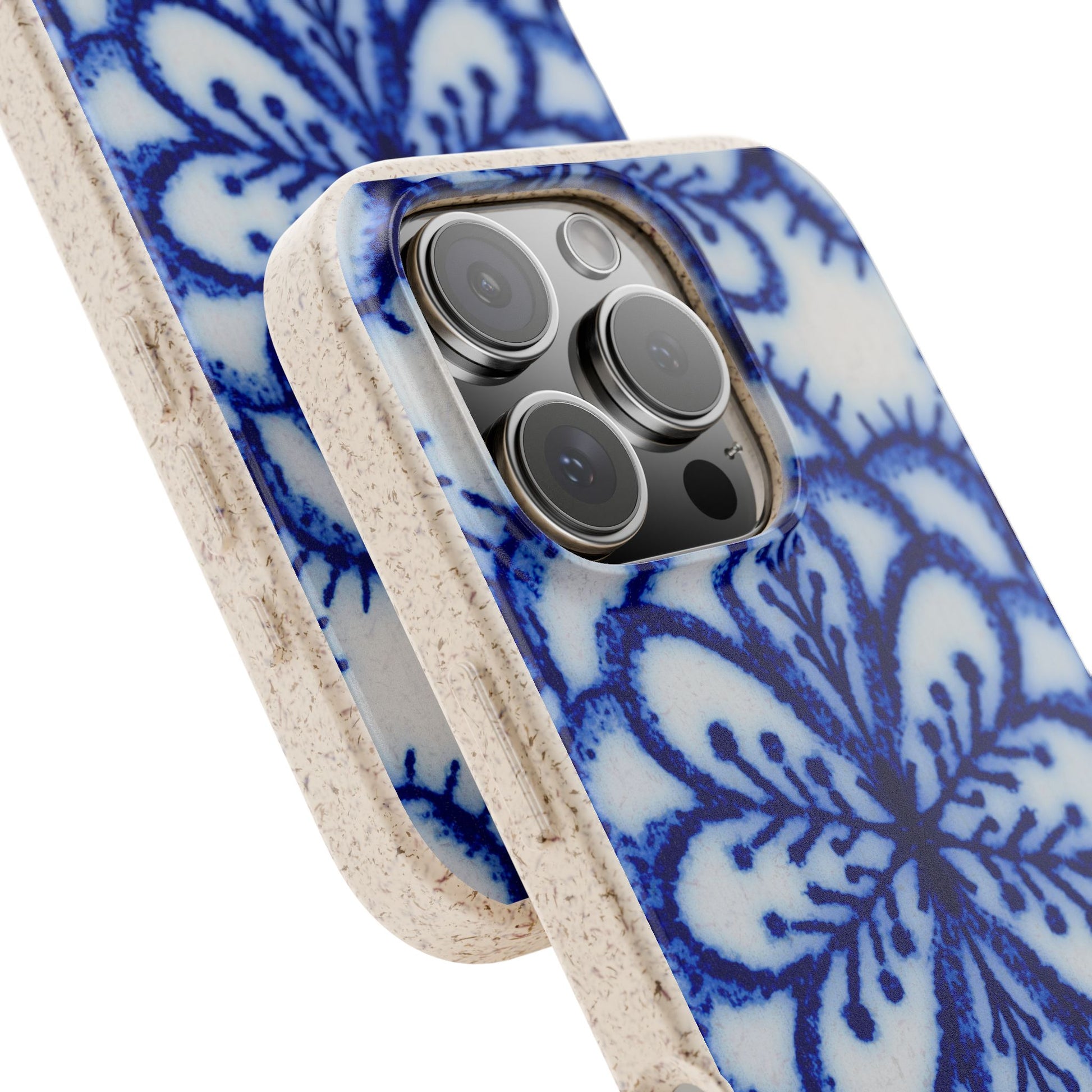A close-up of a phone case with a blue and white floral pattern and a textured beige edge, shown fitted on a smartphone against a white background.