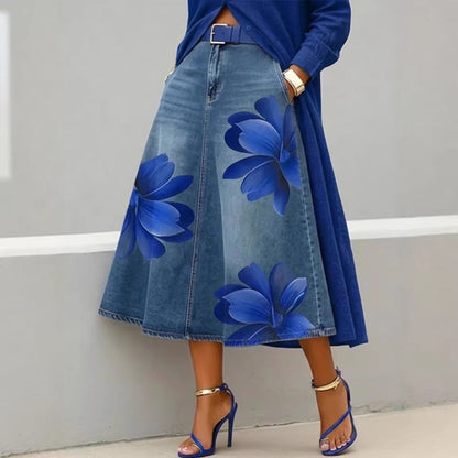 Denim skirt with floral designs worn by a person against a neutral background