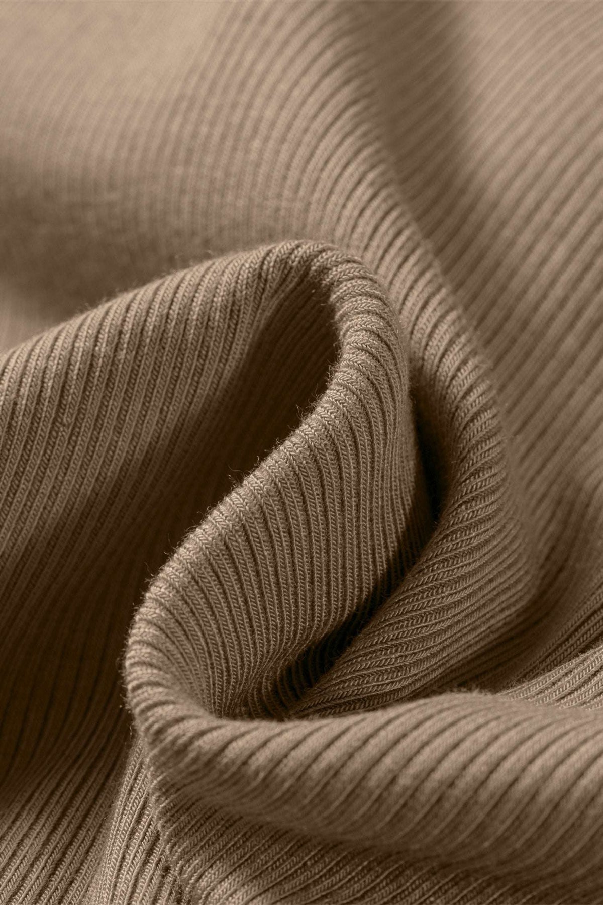 Close-up of folded tan ribbed fabric showing the vertical texture of the Slim Ribbed Padded Tank Top.