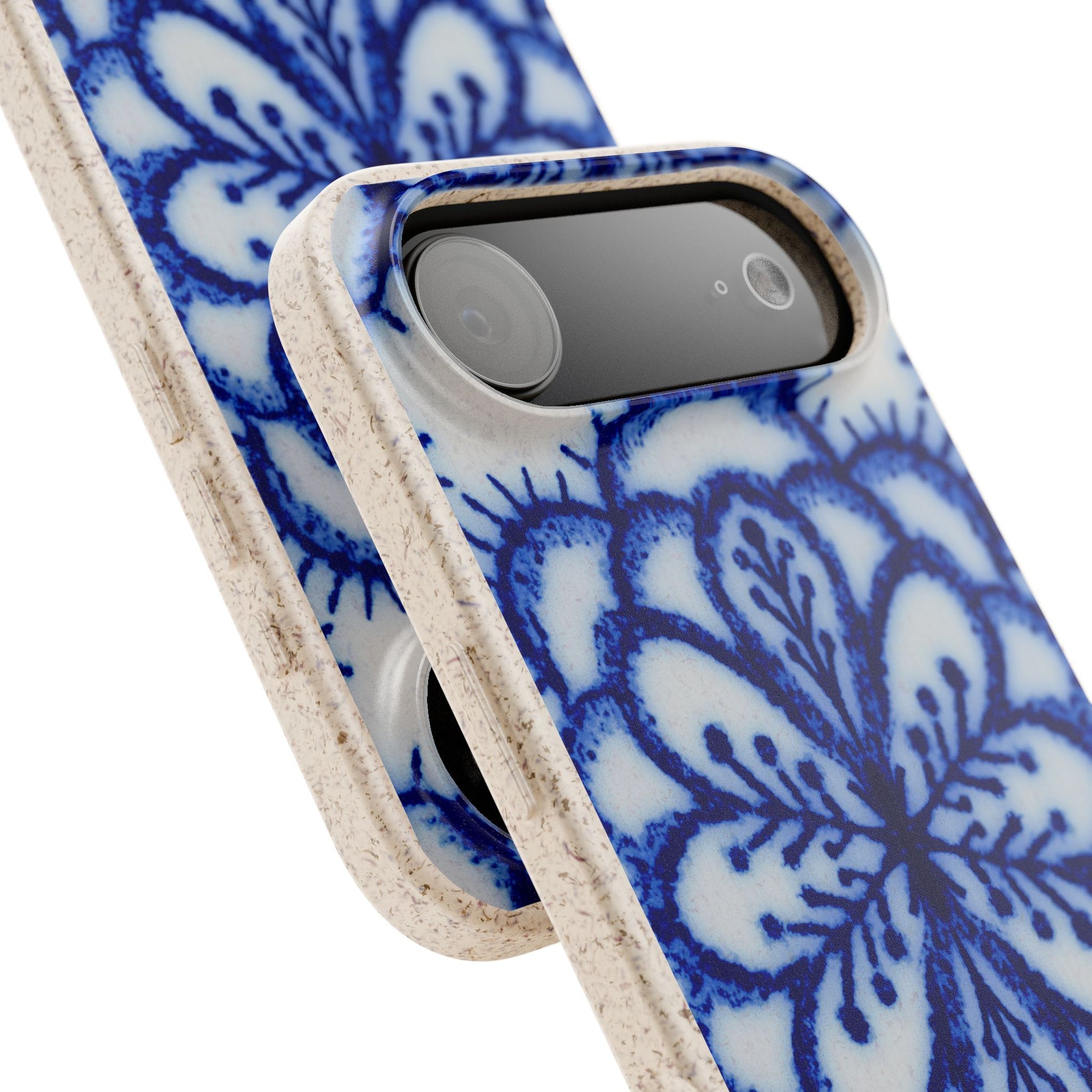 A close-up of a smartphone case with a blue and white floral pattern and a natural beige textured frame, shown on a white background.