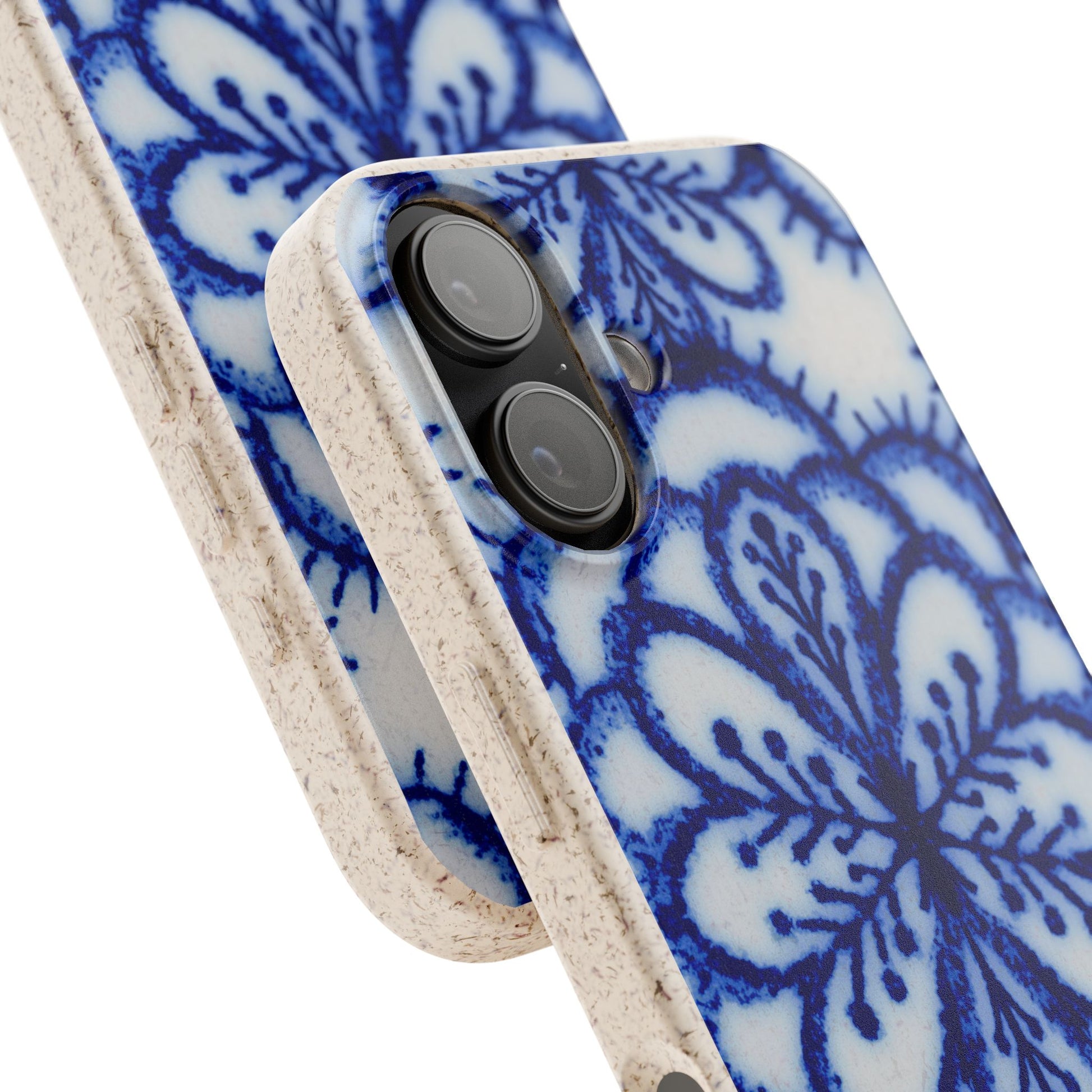 Close-up of a smartphone case with a blue floral mandala pattern on a white base and a textured beige bumper edge, shown against a white background.