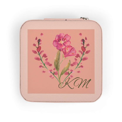 A square zippered pouch in a light pink textured material, featuring a central square print with a pink flower illustration and the initials 'KM' in black script.